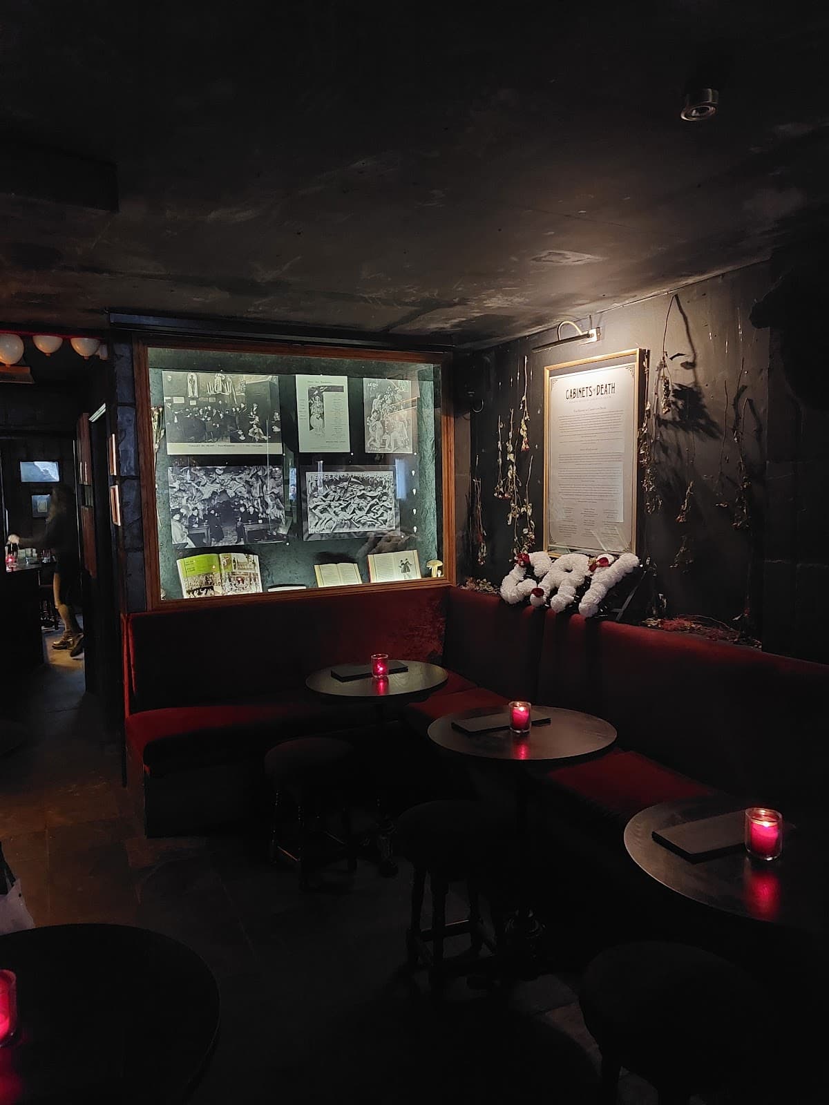 Dimly lit bar area with red candles and cozy seating in London