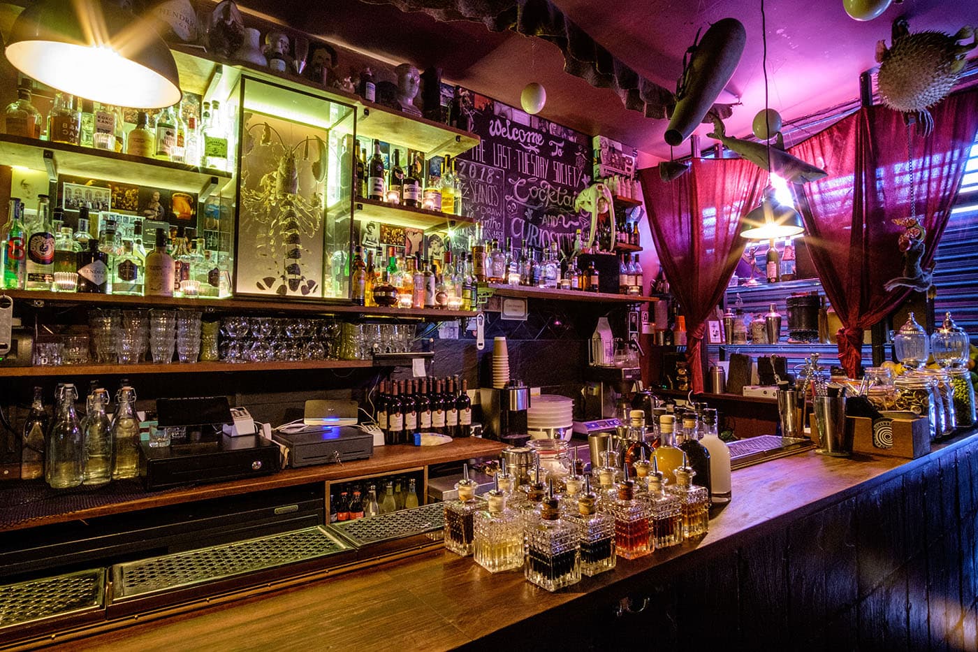 Eclectic bar interior with hanging decor and various liquor bottles