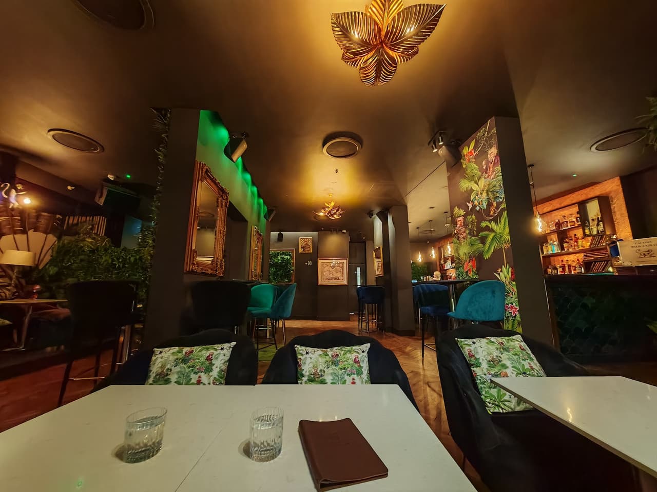 Stylish cocktail bar interior with patterned walls and cozy seating in London