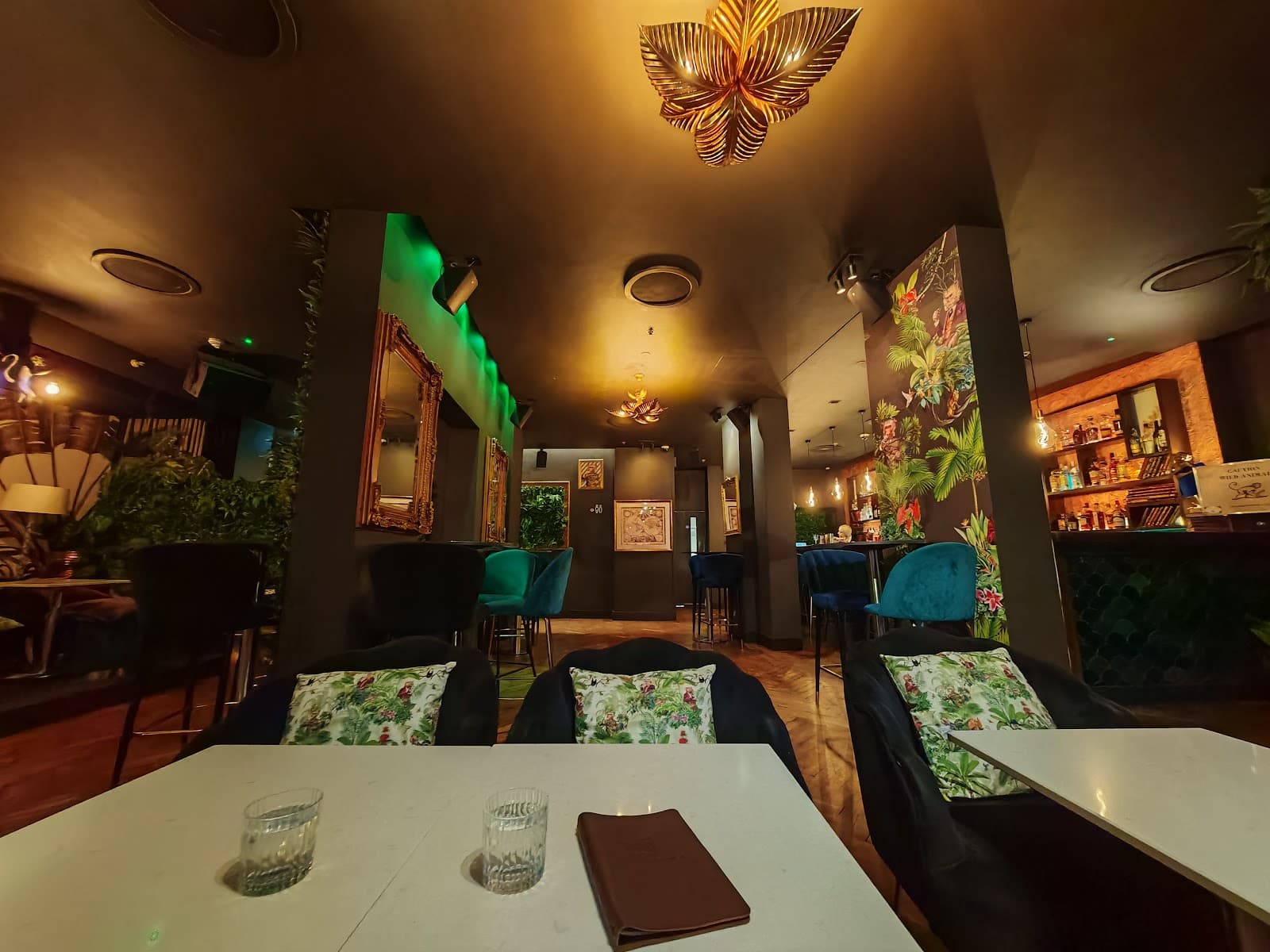 Stylish cocktail bar interior with patterned walls and cozy seating in London