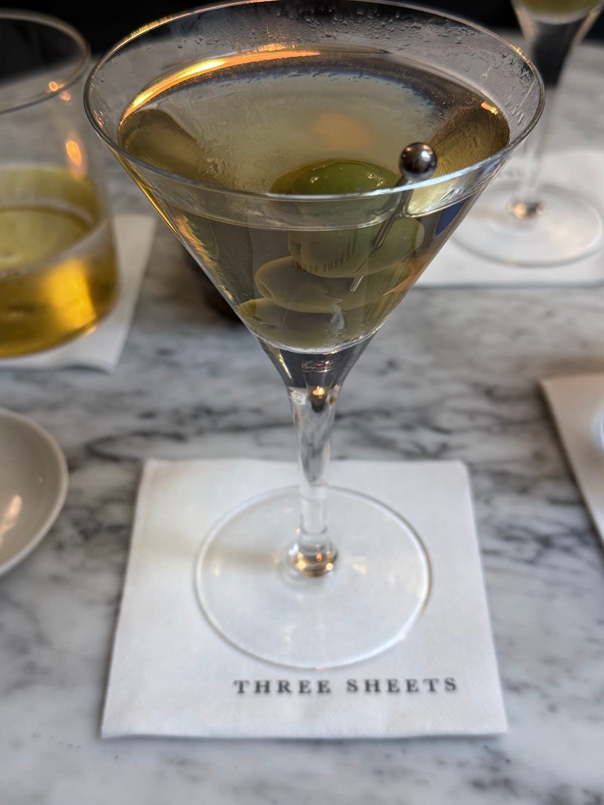 Martini with olive at Three Sheets on marble table in London