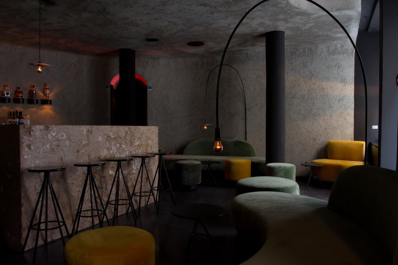 Modern interior with stone bar, stools, and cozy seating
