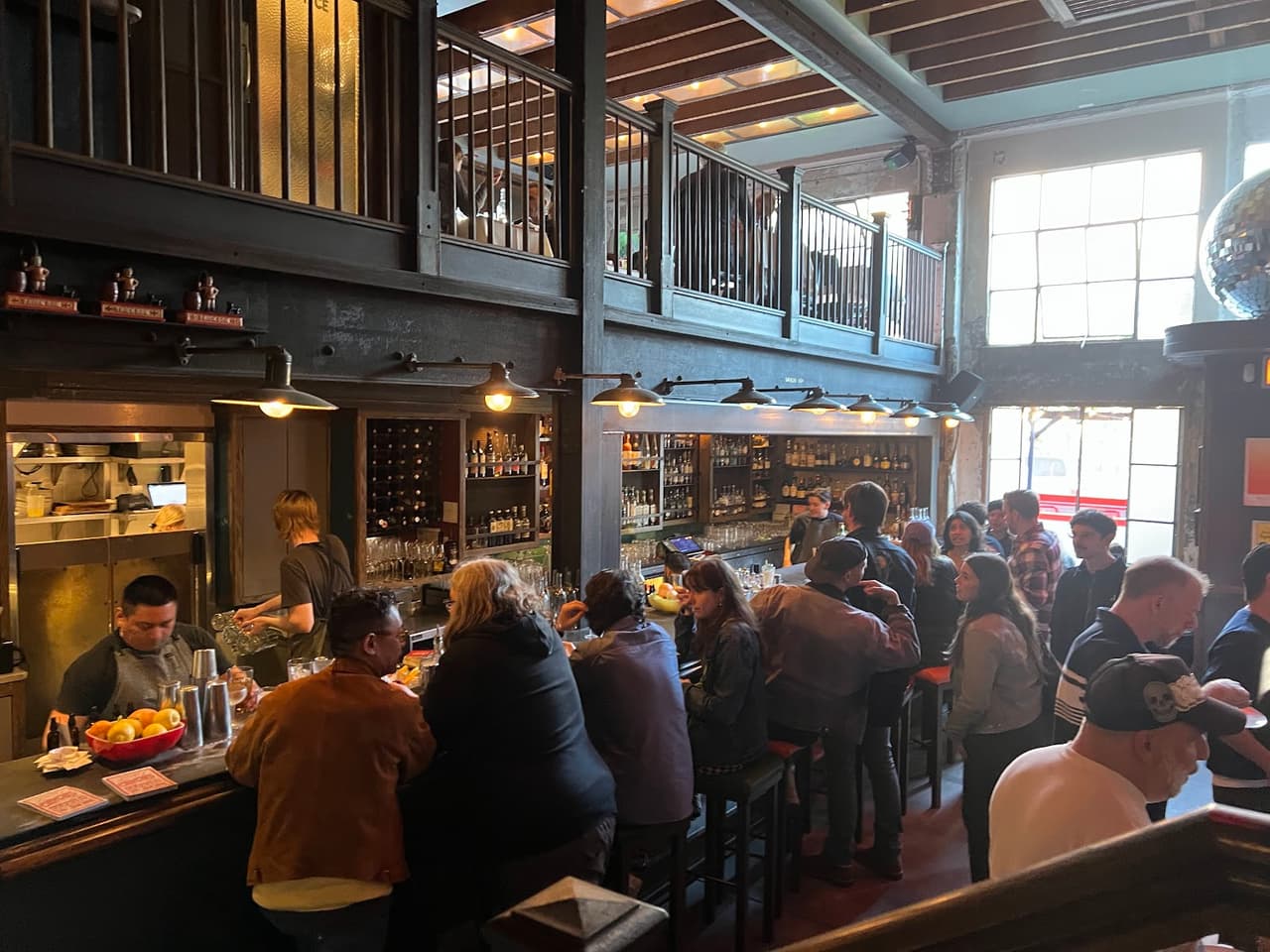 Bustling bar interior with patrons and exposed brick walls in San Francisco