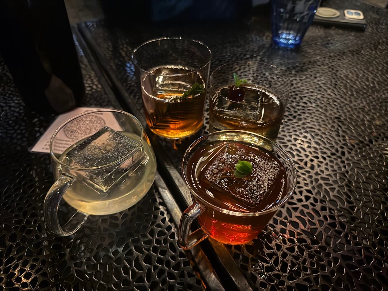 Close-up of various cocktails on a textured table at a bar in San Francisco