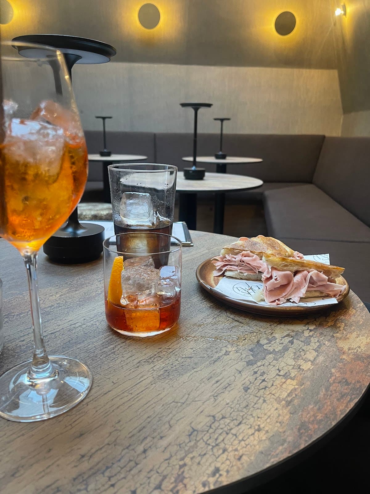Cocktails on a table in a cozy bar setting with sandwiches in London