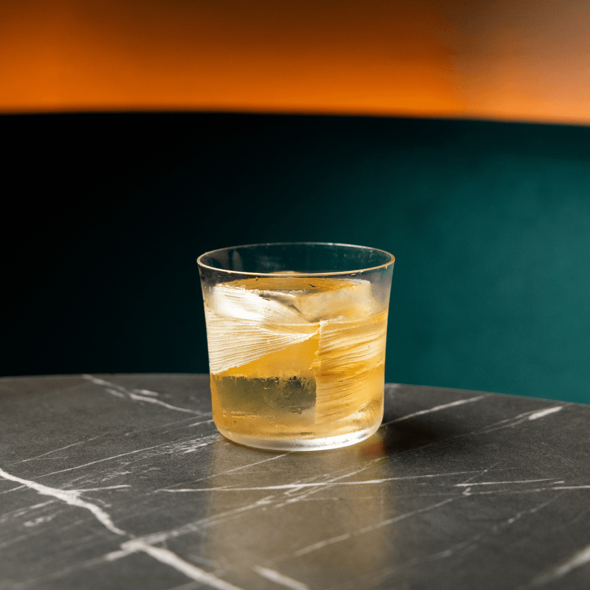 Glass of cocktail on marble table with blurred background in London