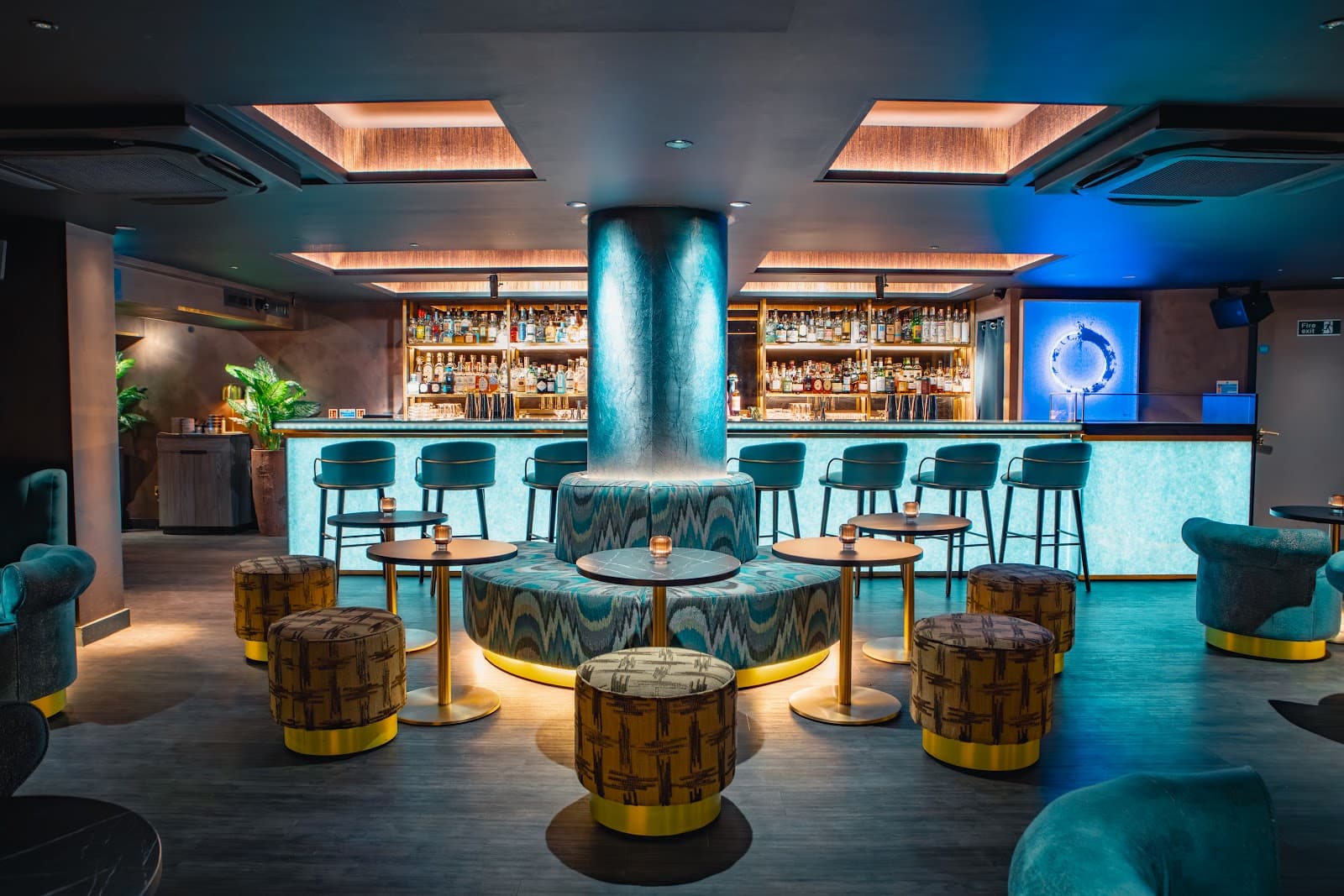 Chic cocktail bar interior with modern stools and illuminated bar counter